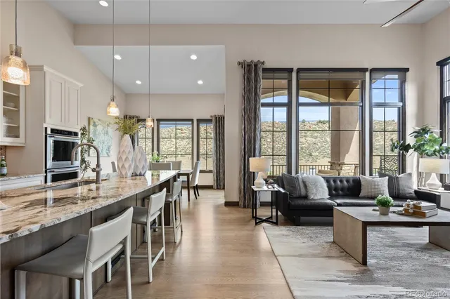 a living room with furniture wooden floor and a large window