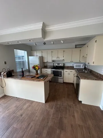 a large kitchen with stainless steel appliances granite countertop a stove a sink dishwasher and a refrigerator