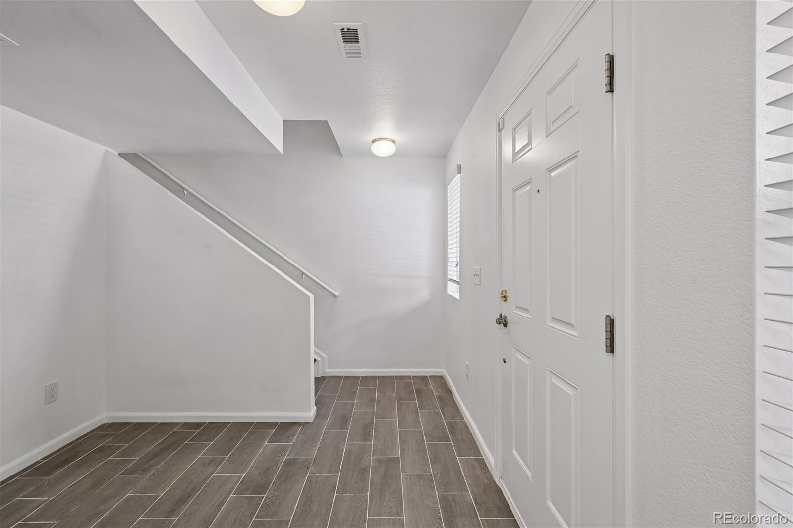 9520 Halstead Lane Lone Tree, CO 80124 - Photo 3 of 29 a view of a hallway with wooden floor and staircase
