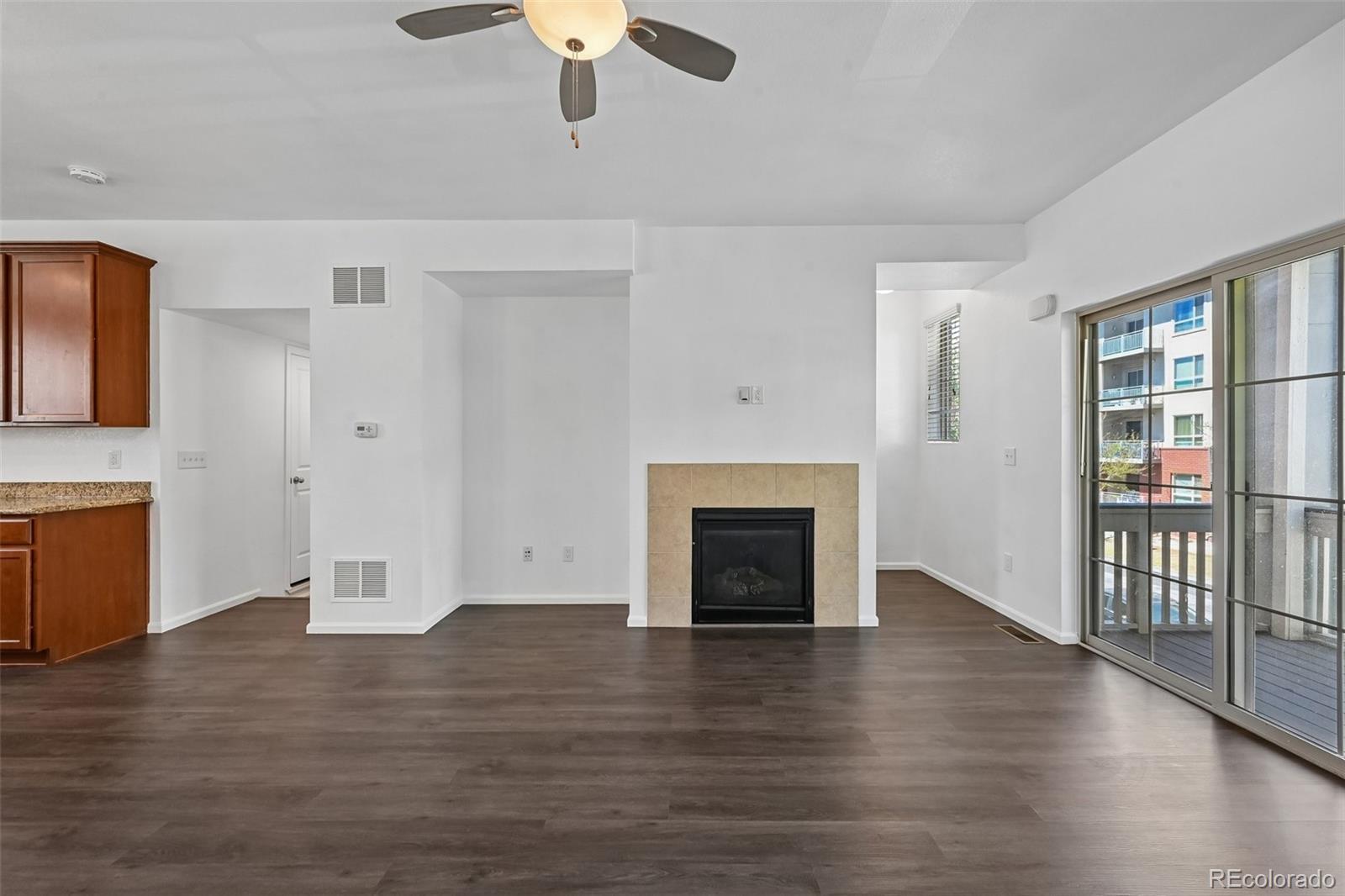 9520 Halstead Lane Lone Tree, CO 80124 - Photo 5 of 29 an empty room with wooden floor fireplace and windows