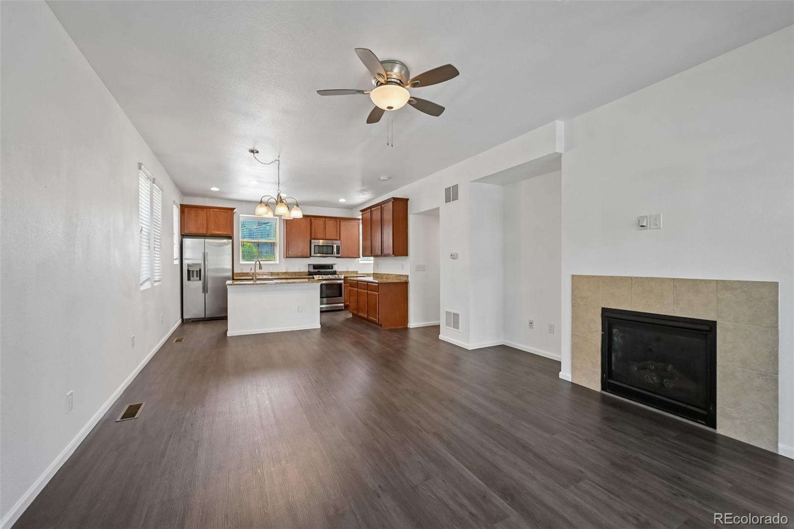 9520 Halstead Lane Lone Tree, CO 80124 - Photo 6 of 29 a view of a kitchen with a fridge wooden floor and a kitchen
