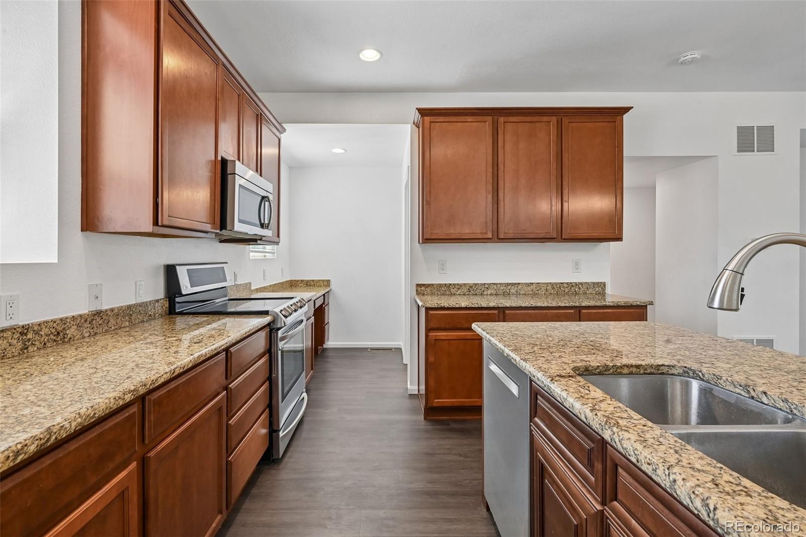 9520 Halstead Lane Lone Tree, CO 80124 - Photo 10 of 29 a kitchen with stainless steel appliances granite countertop a sink stove and cabinets