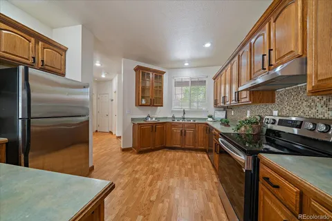 a kitchen with stainless steel appliances granite countertop a sink a stove and a refrigerator