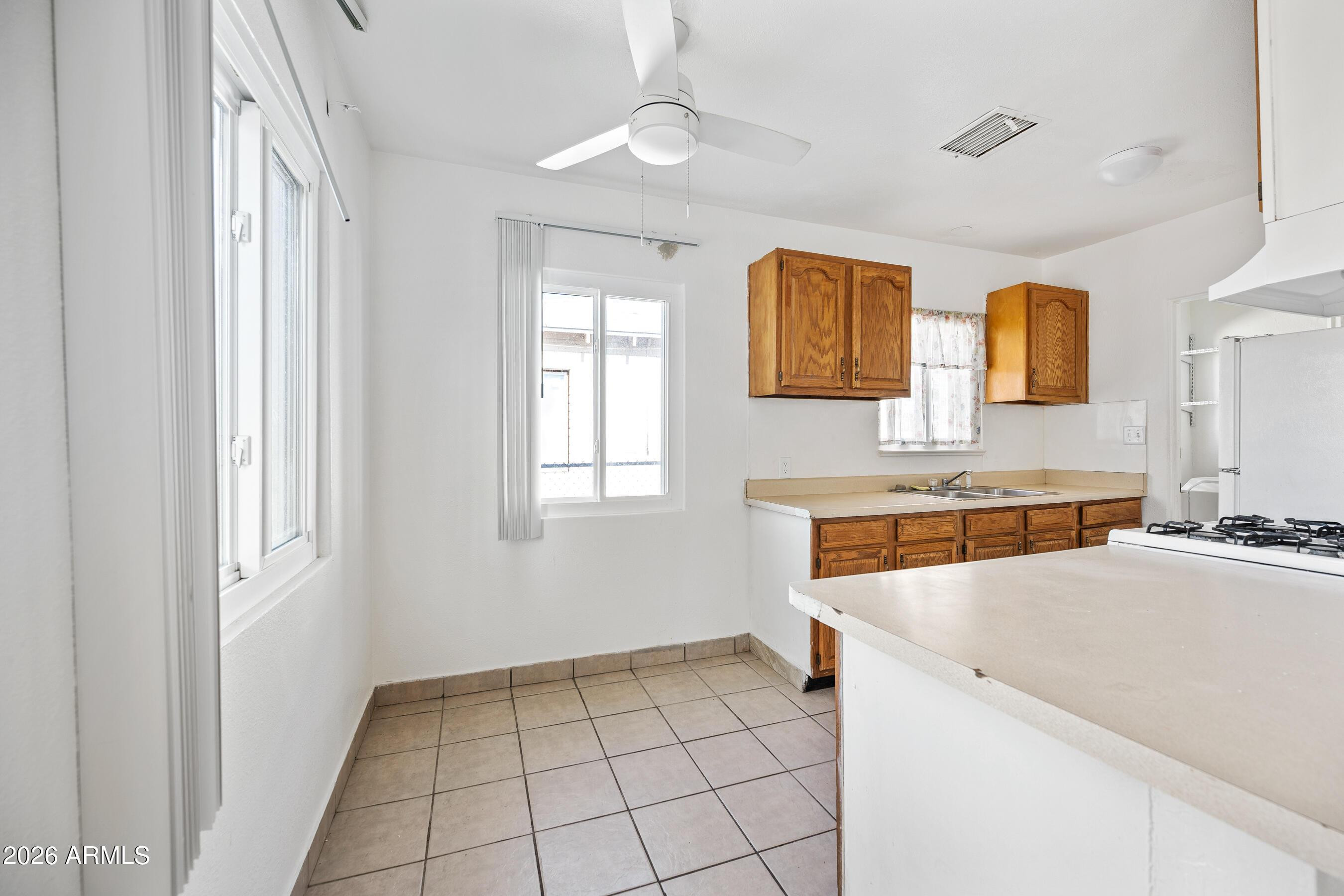 3903 North 12th Street Phoenix, AZ 85014 - Photo 5 of 16 a view of a kitchen with a sink and dishwasher with wooden cabinets