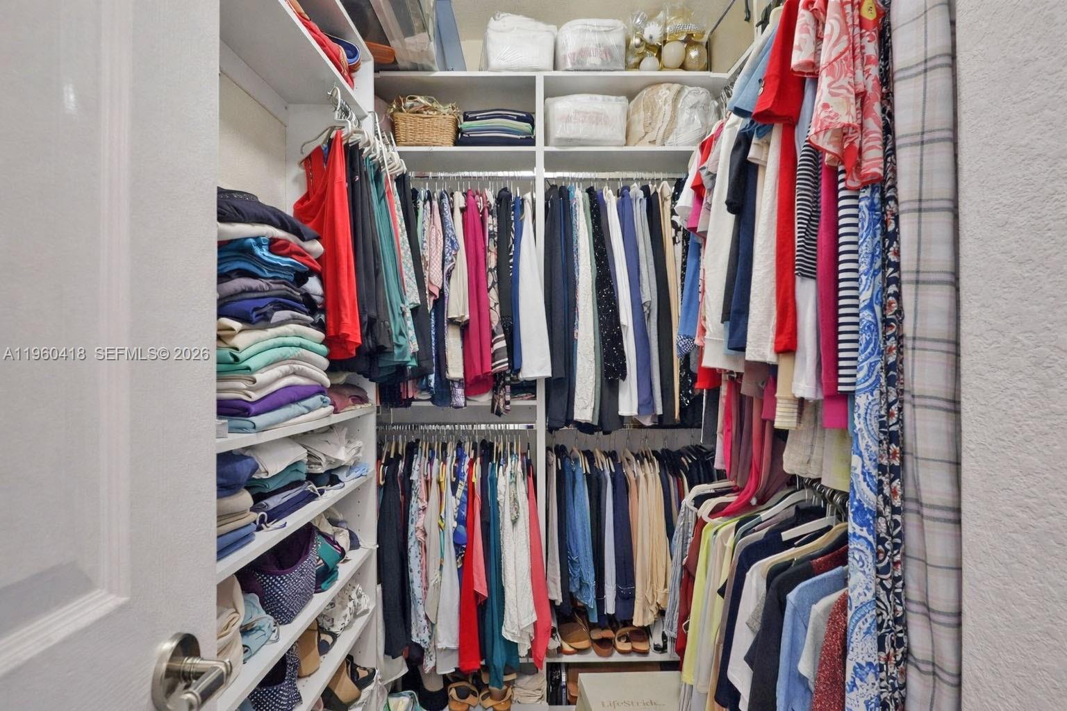 132 Northeast 26th Avenue Homestead, FL 33033 - Photo 37 of 68 a view of walk in closet with clothes