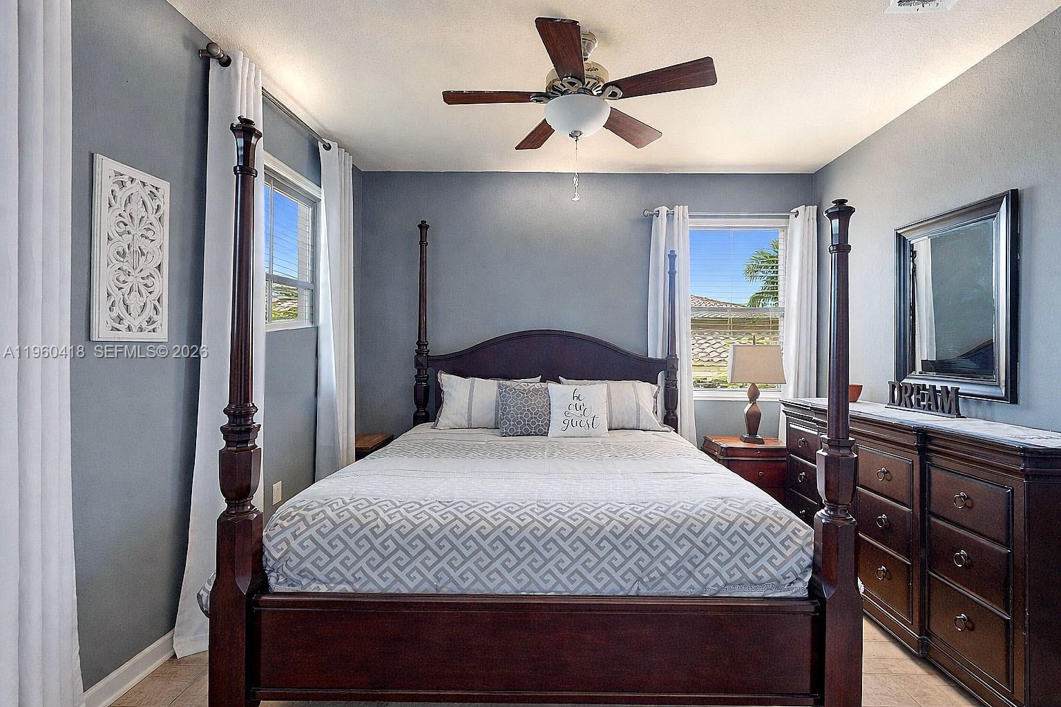 132 Northeast 26th Avenue Homestead, FL 33033 - Photo 39 of 68 a bedroom with a large bed and a chandelier
