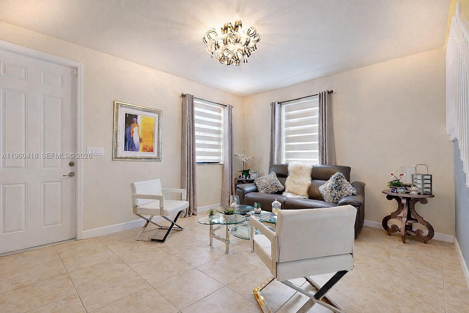 132 Northeast 26th Avenue Homestead, FL 33033 - Photo 9 of 68 a living room with furniture and a chandelier