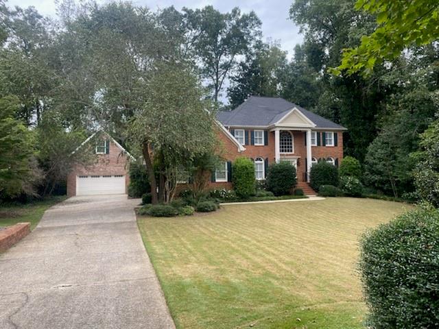 elegant brick home with long driveway leading to side entry garage and a new carriage house for more parking/storage. Use your imagination!