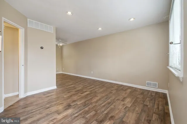 wooden floor in an empty room with a window