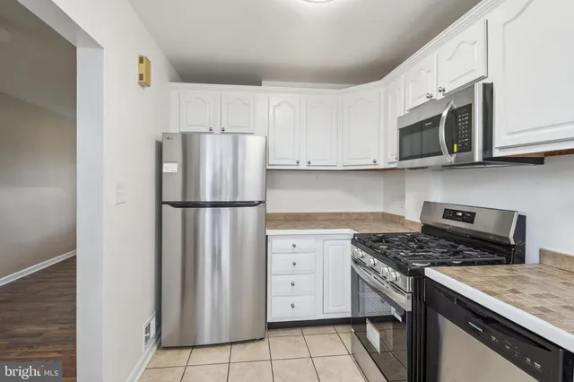 a kitchen with stainless steel appliances granite countertop cabinets and a stove top oven