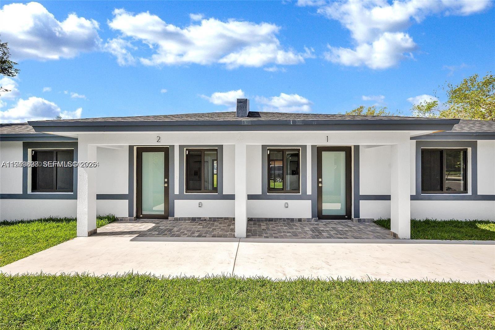 673 Northwest 14th Street, Unit 1 Florida City, FL 33034 - Photo 19 of 21 a front view of a house with a yard and garage
