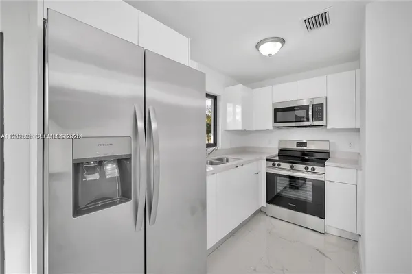 a kitchen with a refrigerator stove and microwave
