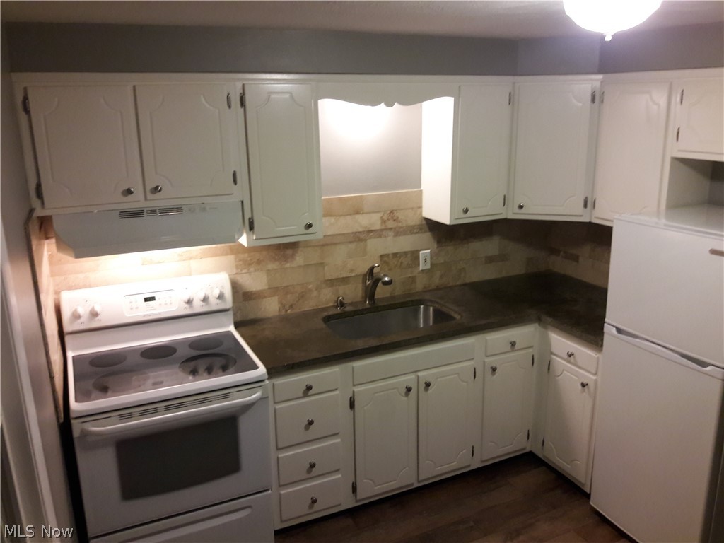 4619 15th Street Northwest Canton, OH 44708 - Photo 15 of 26 Kitchen with dark wood-style floors, travertine backsplash, white appliances. Concrete countertops with undermount sink.