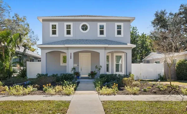 a front view of a house with a yard and potted plants