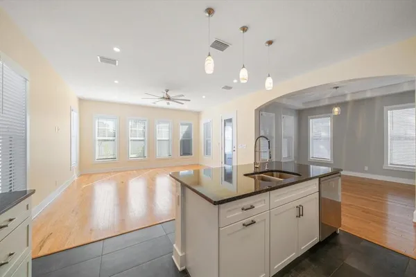 a kitchen with granite countertop a sink and white cabinets