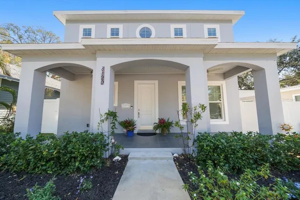 a front view of a house with potted plants