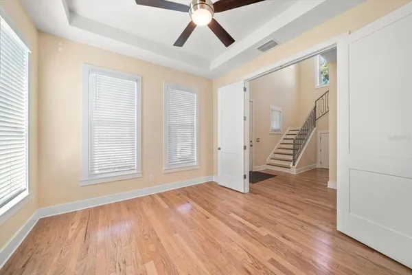a view of an empty room with wooden floor and a window