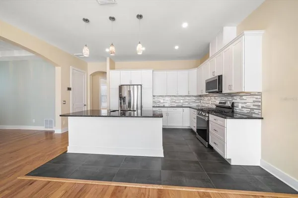 a large kitchen with stainless steel appliances granite countertop a stove a sink and a refrigerator