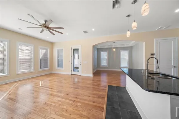 a view of an empty room with window and wooden floor