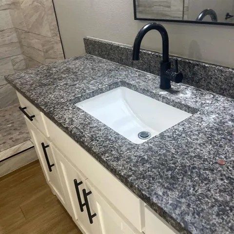 a bathroom with a granite countertop bathtub toilet and sink