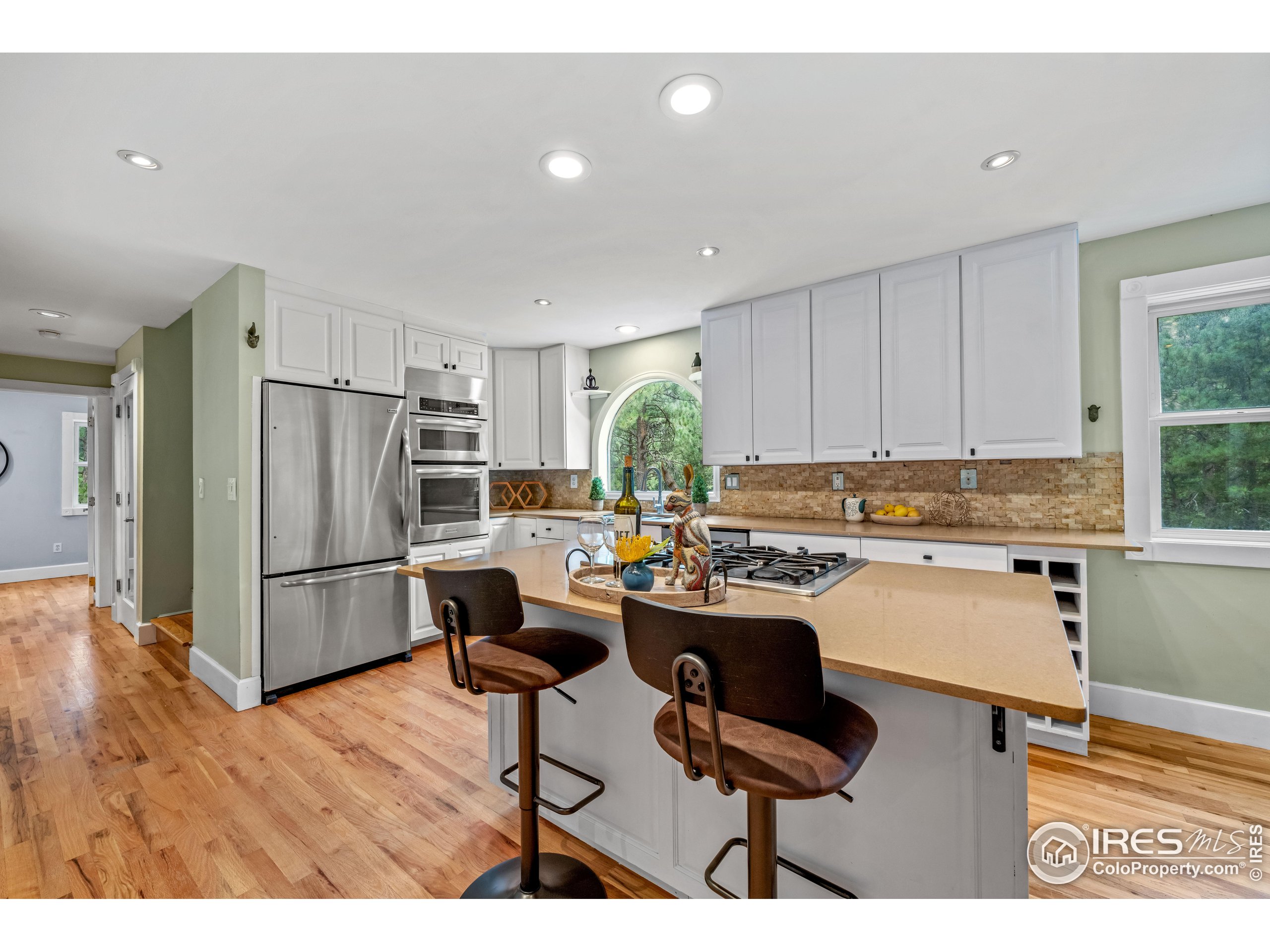 301 Valley Lane Boulder, CO 80302 - Photo 2 of 46 a kitchen with a refrigerator a stove a sink dishwasher with a dining table and chairs with wooden floor