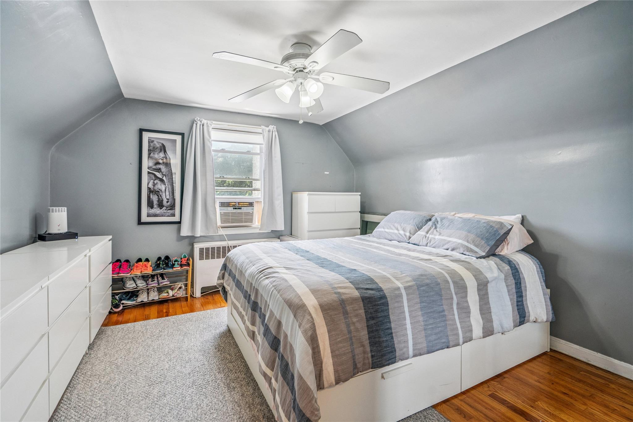 12 Westmoreland Road Merrick, NY 11566 - Photo 23 of 42 a bedroom with a bed and a chandelier