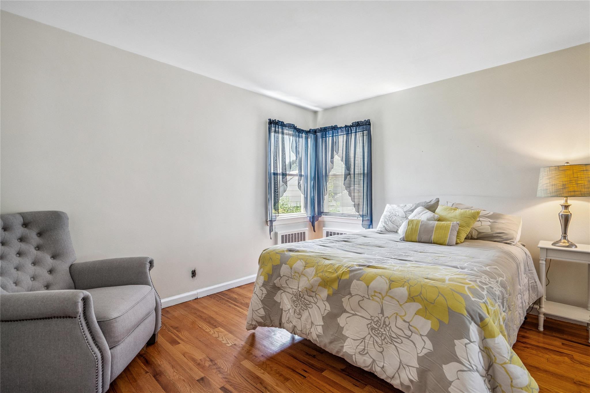 12 Westmoreland Road Merrick, NY 11566 - Photo 30 of 42 a bedroom with a bed and wooden floor