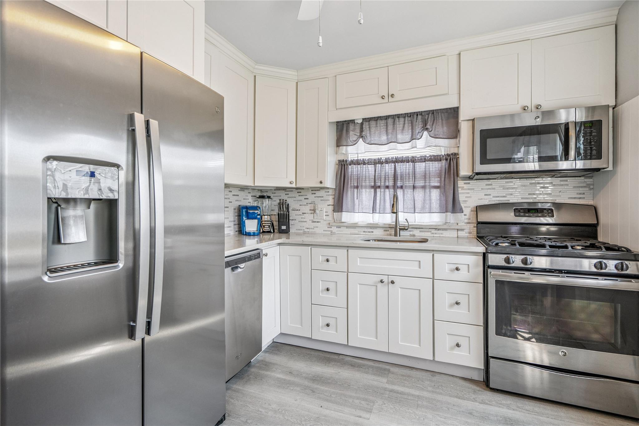 12 Westmoreland Road Merrick, NY 11566 - Photo 33 of 42 a kitchen with stainless steel appliances granite countertop a refrigerator stove and microwave