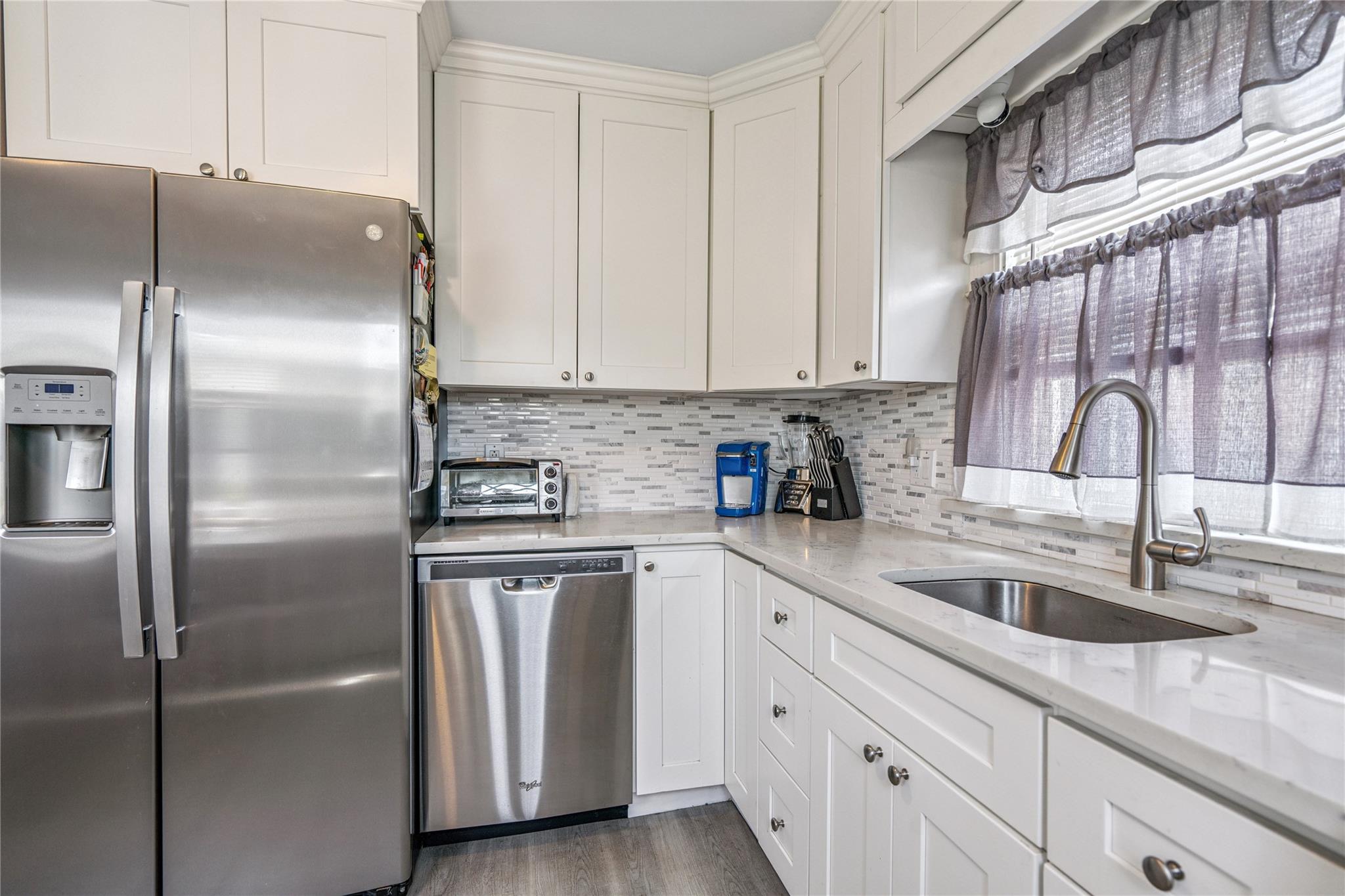 12 Westmoreland Road Merrick, NY 11566 - Photo 36 of 42 a kitchen with stainless steel appliances granite countertop a sink a refrigerator and cabinets