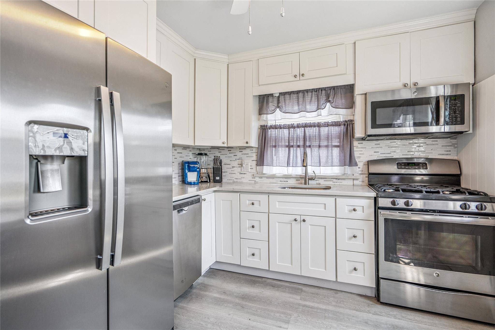12 Westmoreland Road Merrick, NY 11566 - Photo 37 of 42 a kitchen with stainless steel appliances granite countertop a refrigerator stove and sink