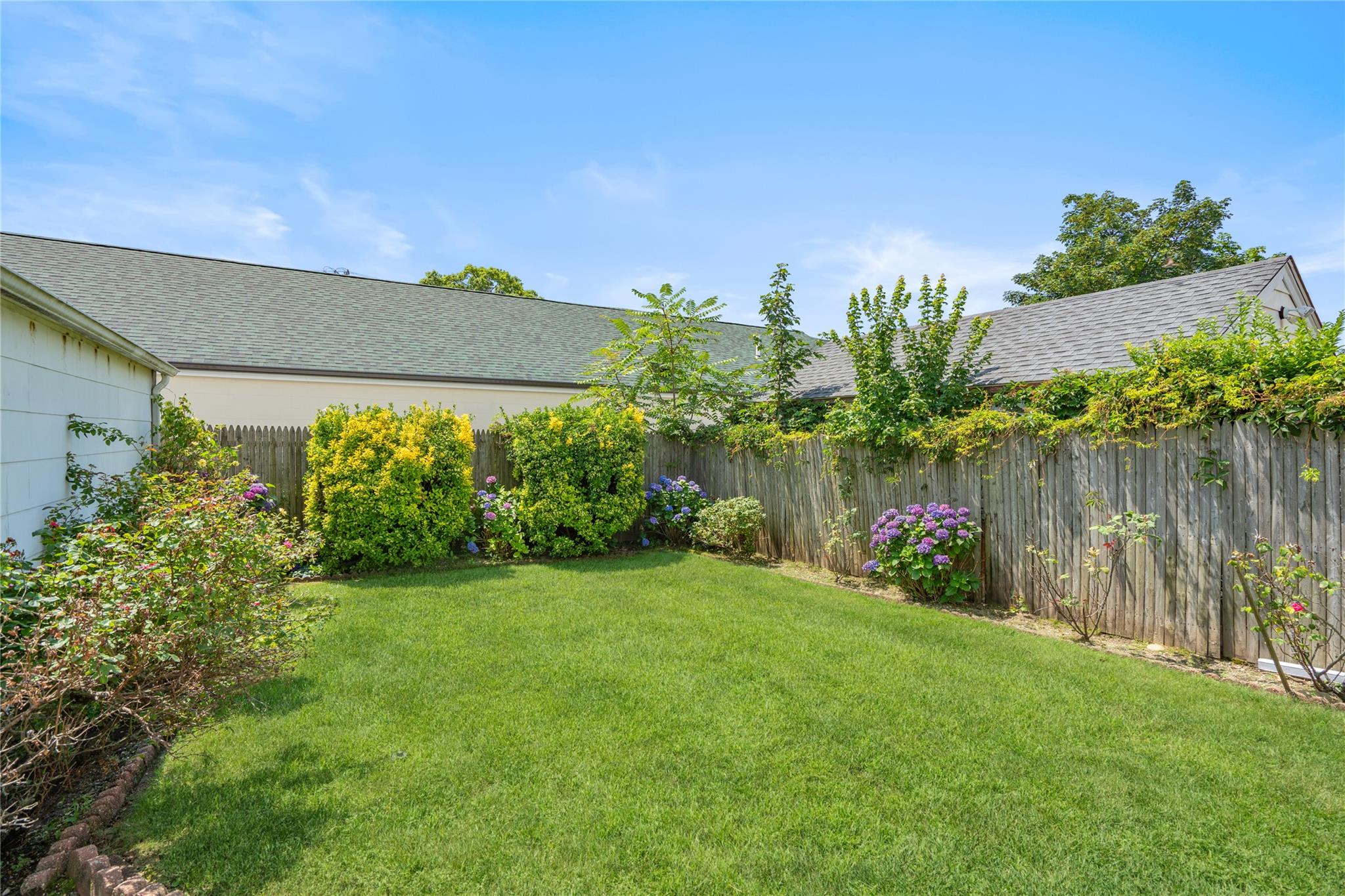 12 Westmoreland Road Merrick, NY 11566 - Photo 4 of 42 a view of a garden with a building in the background