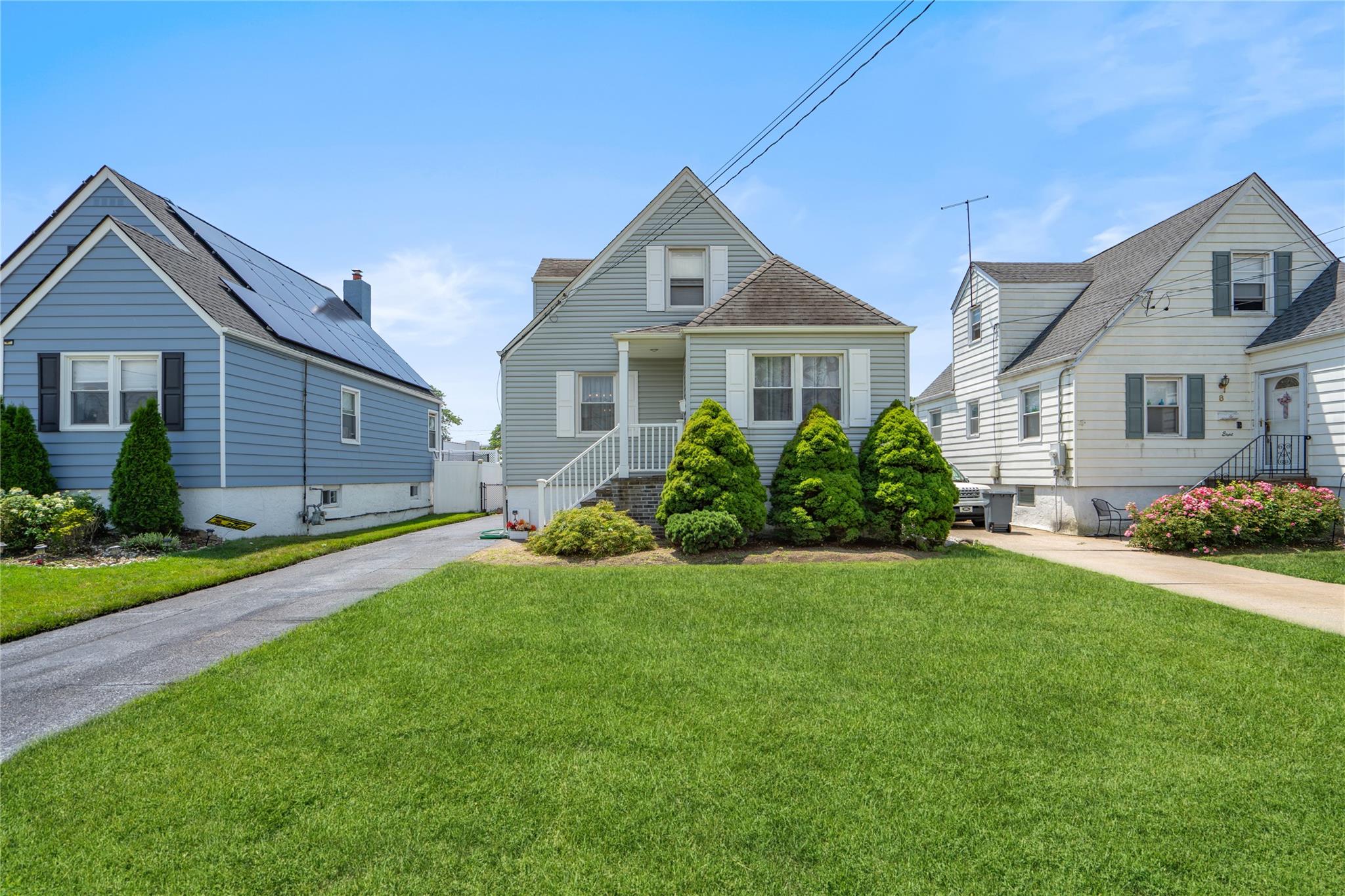 12 Westmoreland Road Merrick, NY 11566 - Photo 9 of 42 a front view of a house with a garden and plants