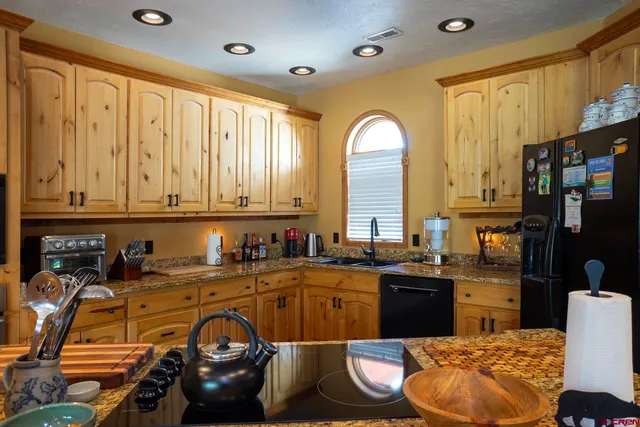 a kitchen with stainless steel appliances granite countertop a refrigerator and a sink