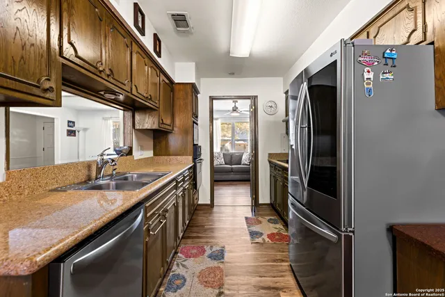 a kitchen with stainless steel appliances granite countertop a refrigerator a sink and dishwasher