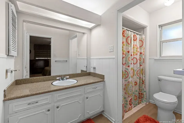 a bathroom with a granite countertop sink toilet and shower