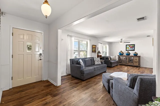 a living room with furniture chandelier and a window