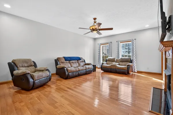 a kitchen with stainless steel appliances granite countertop a refrigerator a sink dishwasher a oven and a dining table with wooden floor