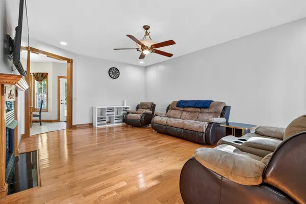 a kitchen with granite countertop a refrigerator a stove a sink dishwasher a dining table and chairs with wooden floor