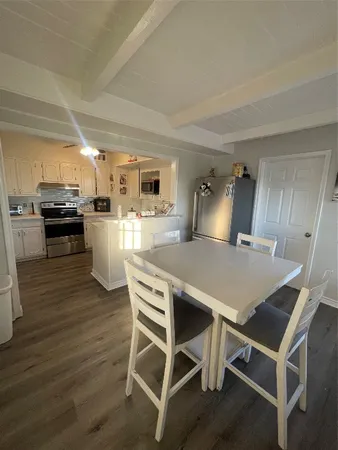 a kitchen with kitchen island a stove a table and chairs in it
