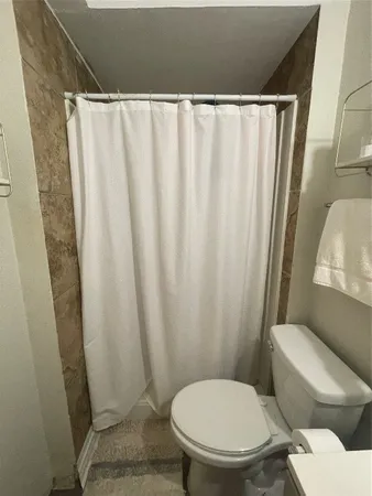 a white toilet sitting next to a shower curtain