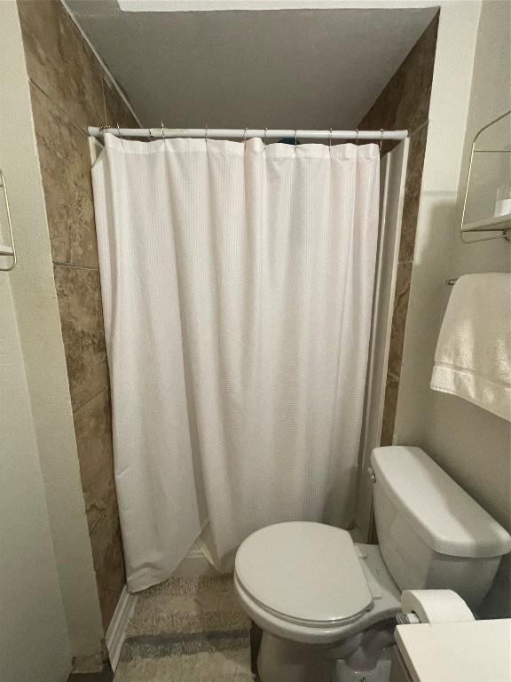 611 Sarah Street Edna, TX 77957 - Photo 19 of 31 a white toilet sitting next to a shower curtain