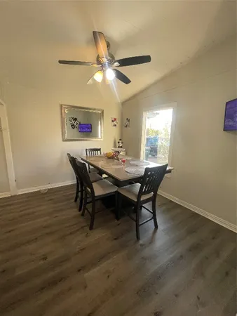 a dining room with wooden floor a chandelier a wooden table and chairs