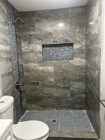 a bathroom with a toilet and a shower