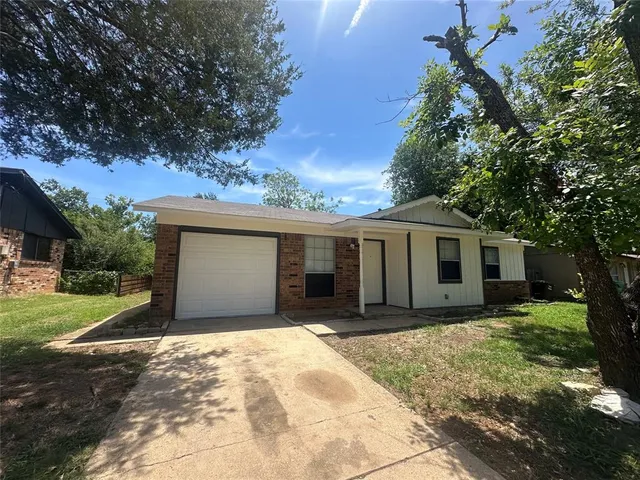 a front view of house with yard and trees around