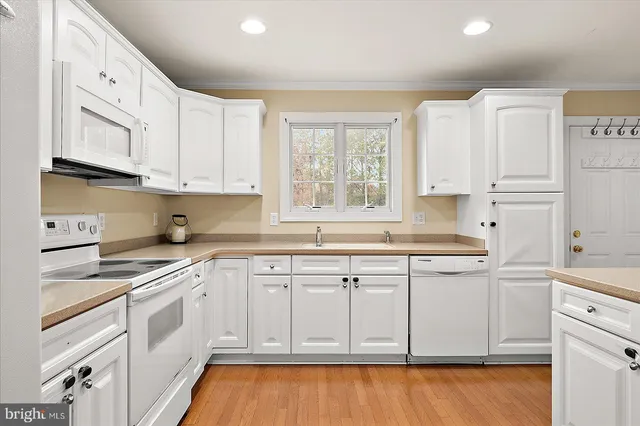 a kitchen with stainless steel appliances granite countertop a stove a sink a refrigerator with wooden floor and cabinets