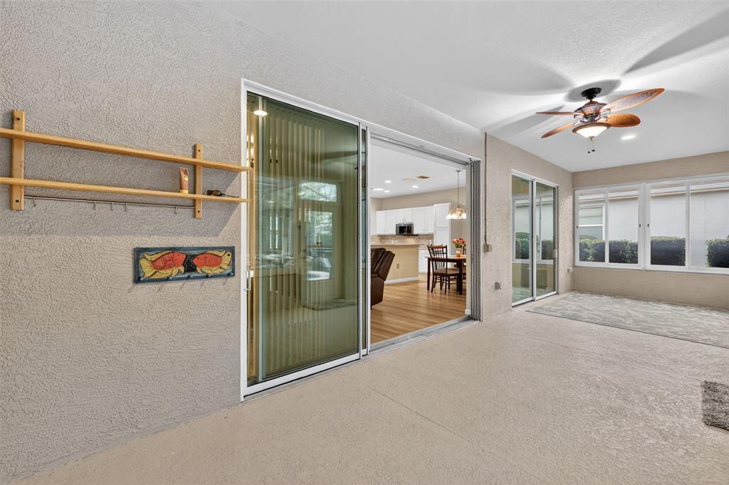 9611 Southwest 71st Loop Ocala, FL 34481 - Photo 26 of 31 a view of a hallway with wooden floor and chandelier