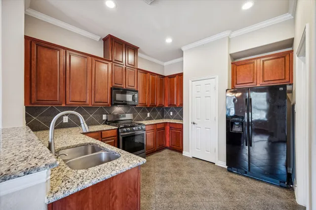 a kitchen with stainless steel appliances granite countertop a sink stove and refrigerator