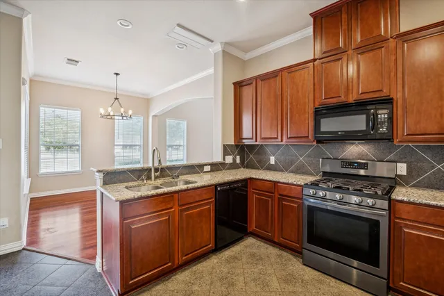 a kitchen with stainless steel appliances granite countertop wooden cabinets stove top oven and sink
