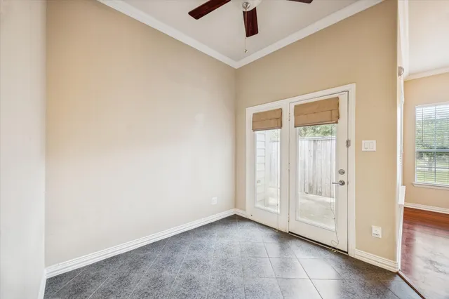 an empty room with ceiling fan and window