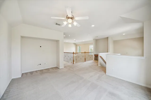 a view of a big room with wooden floor and a ceiling fan